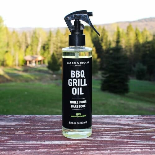 BBQ grill oil bottle on wooden surface with forest background