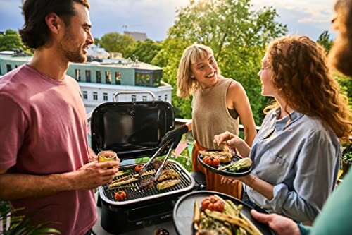 Group of friends enjoying a barbecue on a balcony.