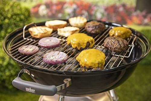 Grill with burgers, onions, and buns cooking.