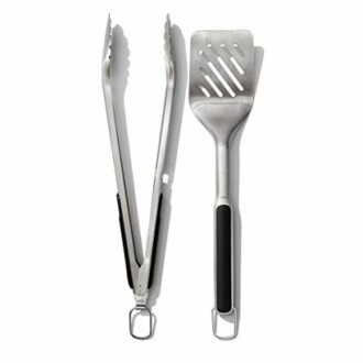 Set of metal BBQ grill tools including tongs and spatula.