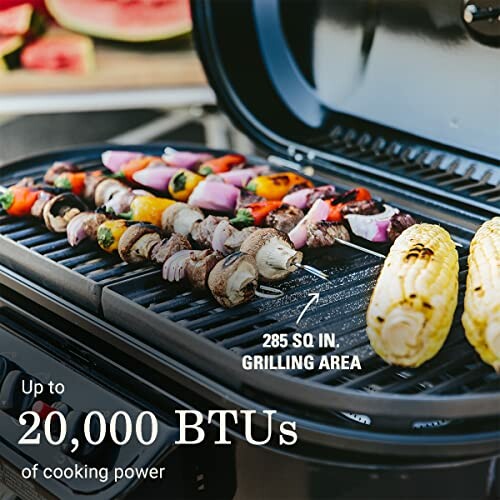 Portable gas grill with skewers and corn grilling.