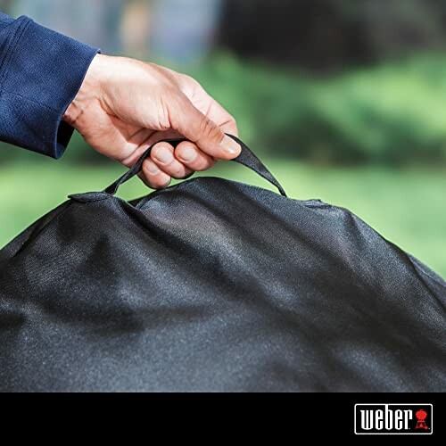 Person holding a Weber grill cover